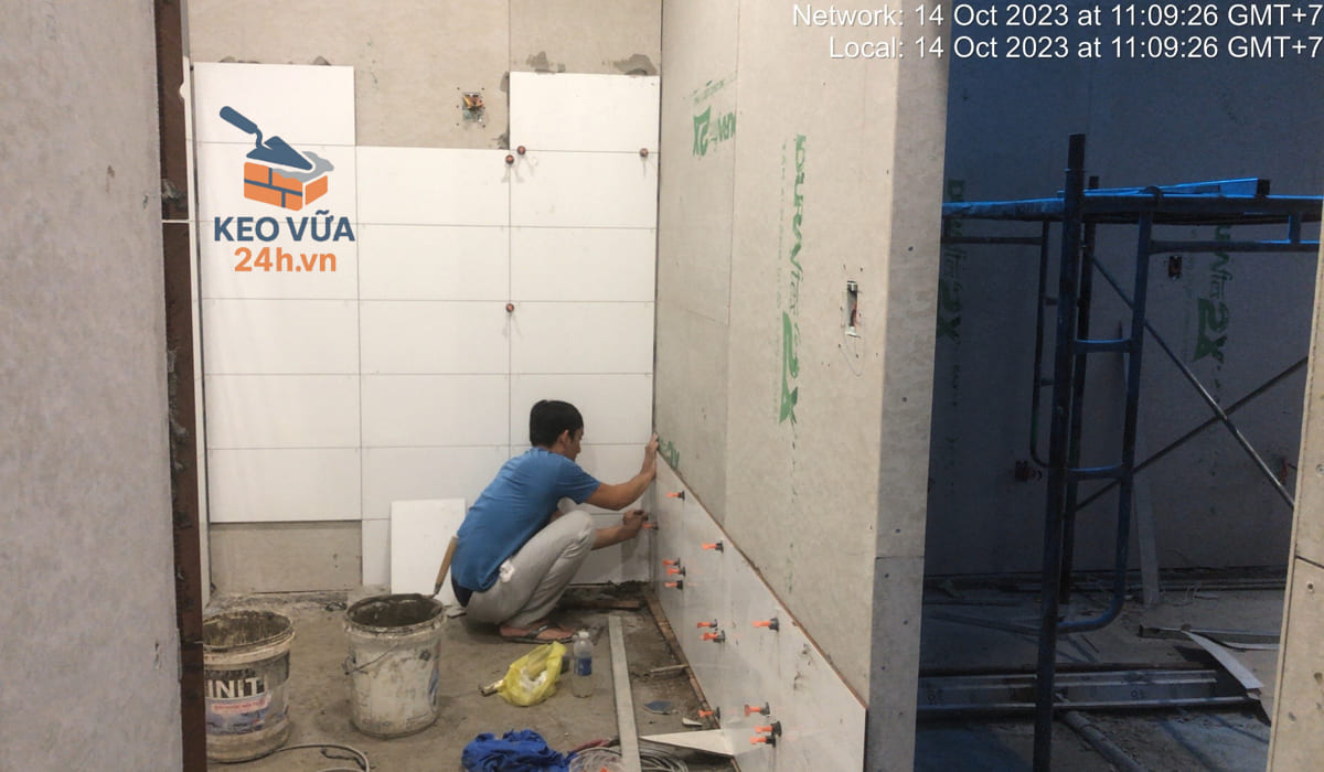 Thi công ốp gạch tường bằng keo dán gạch chuyên dụng.