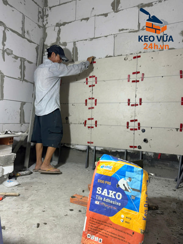 Công nhân ốp gạch lên tường bê tông nhẹ bằng keo dán gạch Sako chuyên dụng.