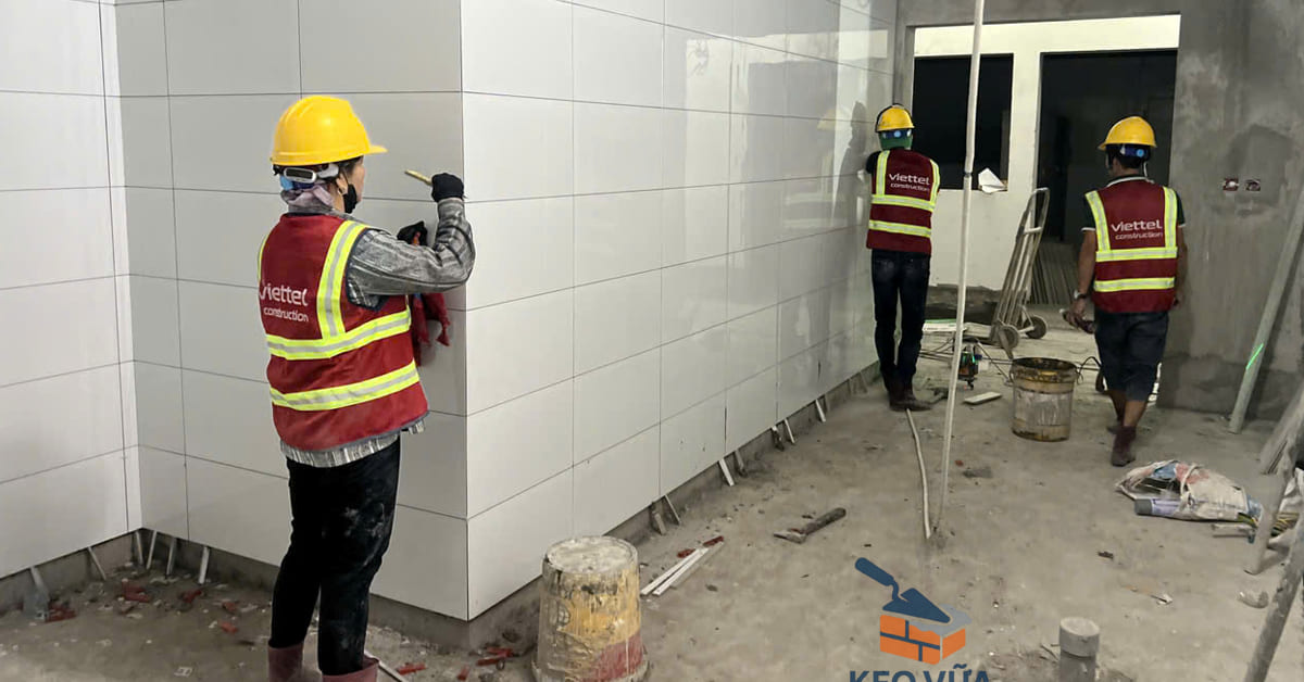 Công nhân thi công chà ron mạch gạch ốp tường