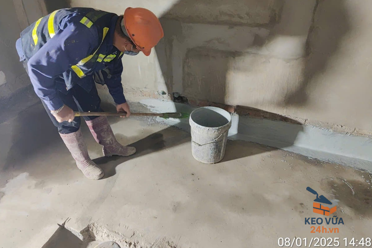 Công nhân quét lớp keo chống thấm khu tường nhà vệ sinh.