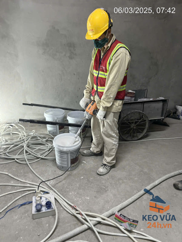 Công nhân pha trộn keo chống thấm trước khi thi công bằng máy.