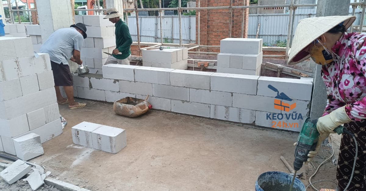 Công nhân căn chỉnh viên gạch AAC sau khi trải vữa, đảm bảo mạch vữa khít và đều.