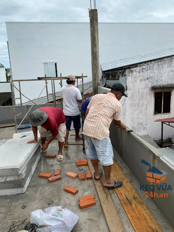 Nhóm thợ sử dụng keo dán tấm để liên kết tấm bê tông nhẹ với nhau, đảm bảo độ bám chắc và chống co ngót hiệu quả.