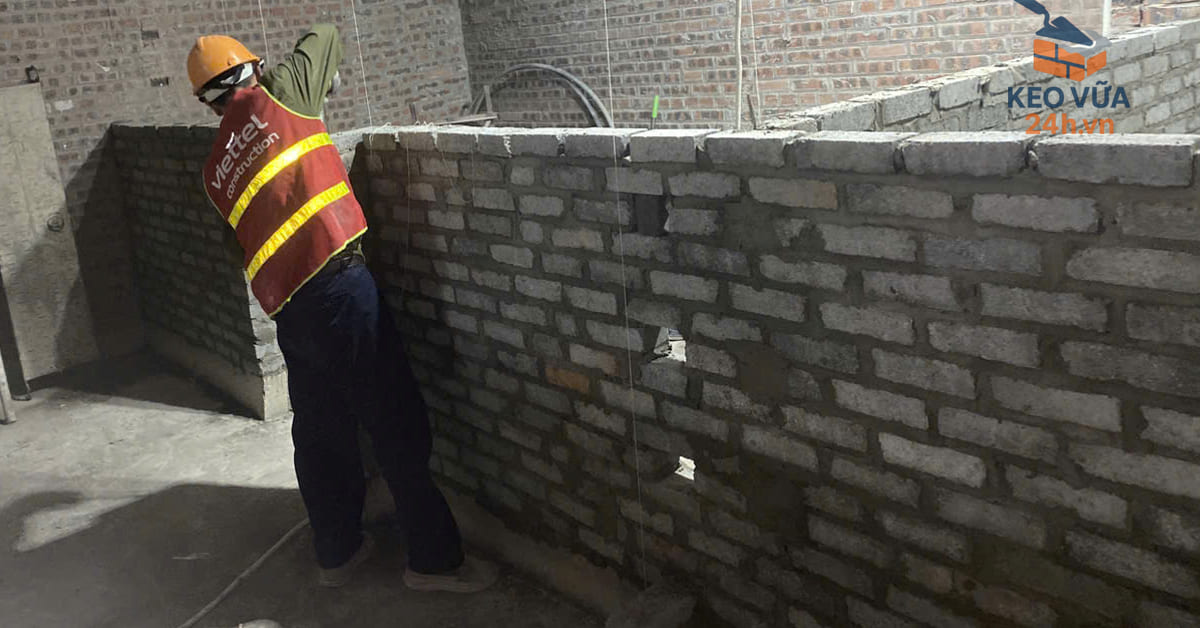 Công nhân thi công xây dựng tường bằng vữa khô trộn sẵn, đảm bảo chất lượng công trình tại Hà Nội.
