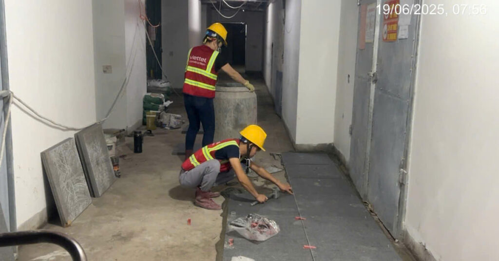 Thợ thi công ốp lát gạch đá bằng keo dán gạch tại công trình khách sạn 5 sao.
