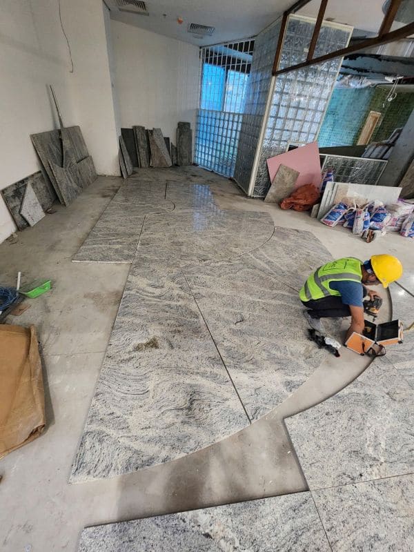Thợ thi công đá lát nền tự nhiên dùng keo chuyên dụng.
