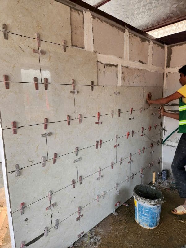 Ốp gạch tường nhà vệ sinh, nhà tắm bằng keo dán gạch. Lớp keo bám dính chắc, chống thấm tốt.